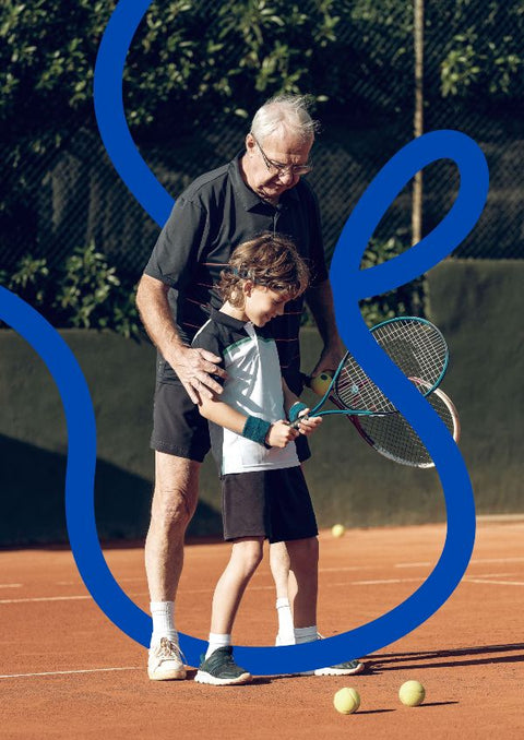 Persona mayor con un niño jugando al tenis